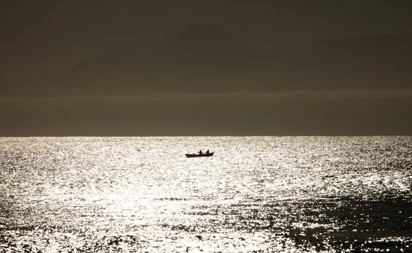 Fishing boat on golden sunset sea